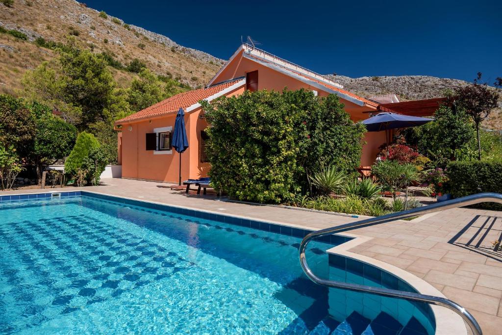 una villa con piscina di fronte a una casa di House Aquarius a Podstrana