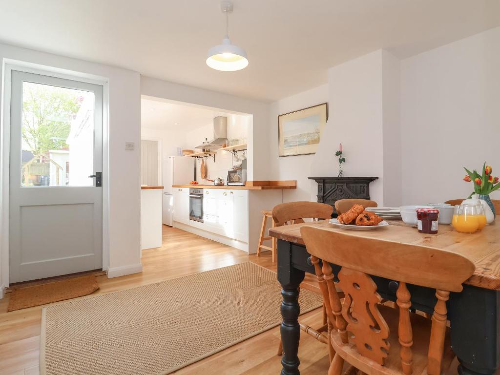 a kitchen and dining room with a table and chairs at Victoria Cottage in Saxmundham