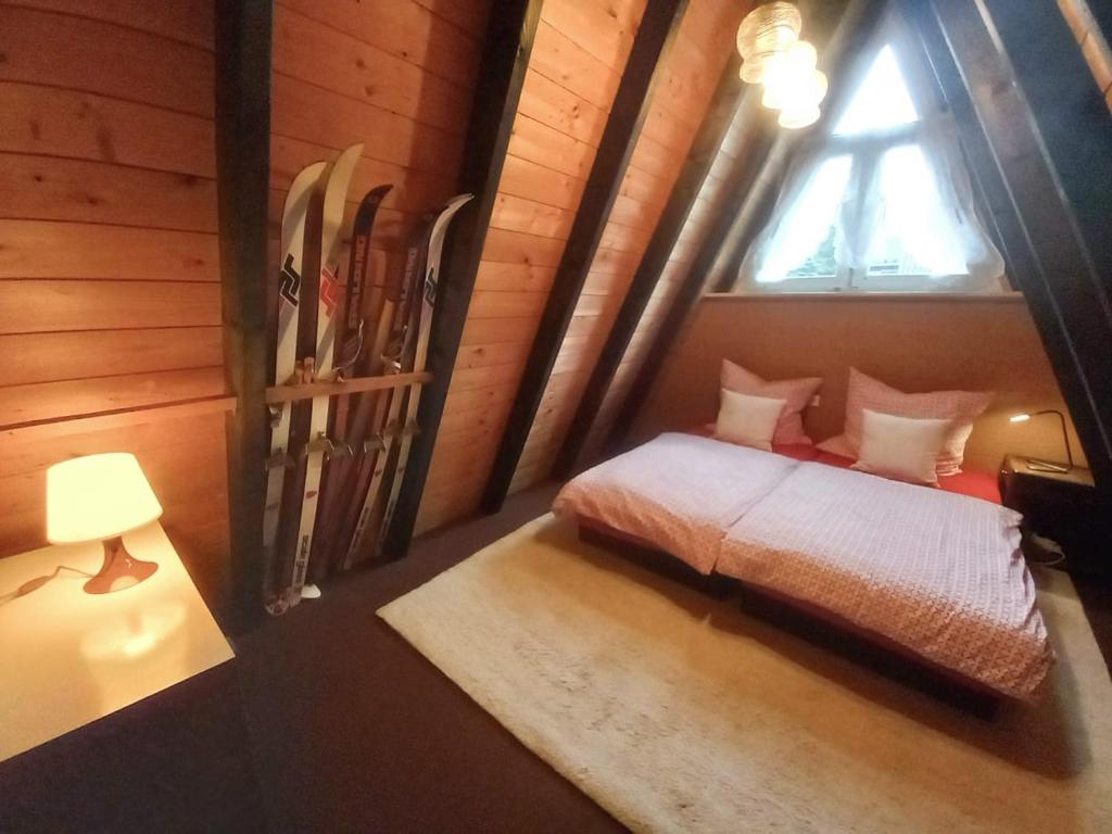 a bedroom with a bed and a window with skis at Gemütliches Ferienhaus mit sonniger Terrasse Frankenwald nähe Badesee Smart-TV in Lichtenberg