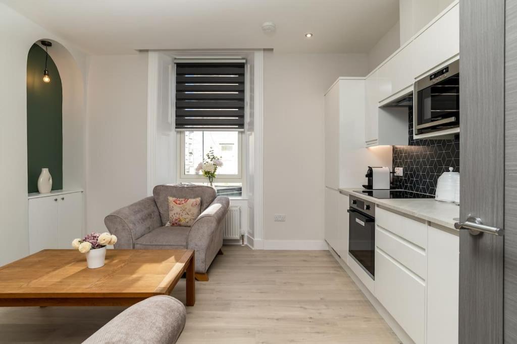 a kitchen and living room with a table and a couch at Heart of Aberdeen * Ground Floor in Aberdeen
