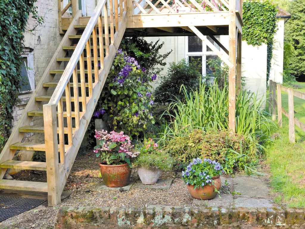 Hollesley的住宿－夜鶯鄉村別墅，一座拥有木楼梯和盆栽植物的花园