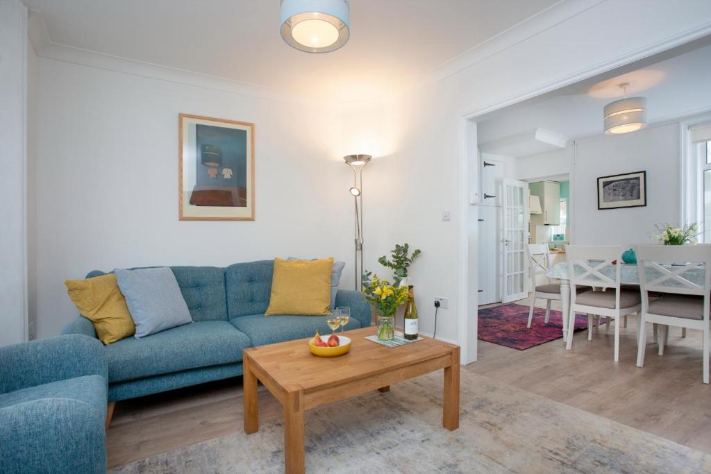 a living room with a blue couch and a table at Holmdale House in Sidmouth