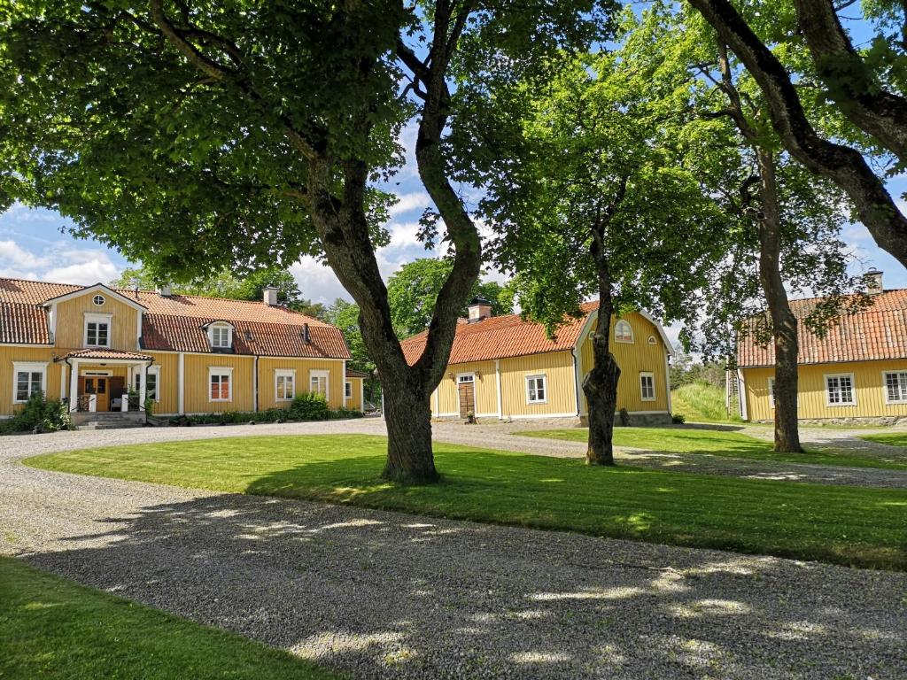 un gruppo di alberi di fronte a una casa di North Wing - Sviten a Enköping
