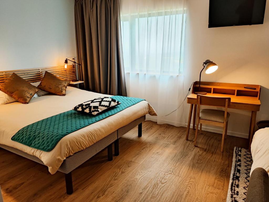 een hotelkamer met een bed, een bureau en een raam bij Auberge du Fort Pélissier in Pont-Saint-Vincent