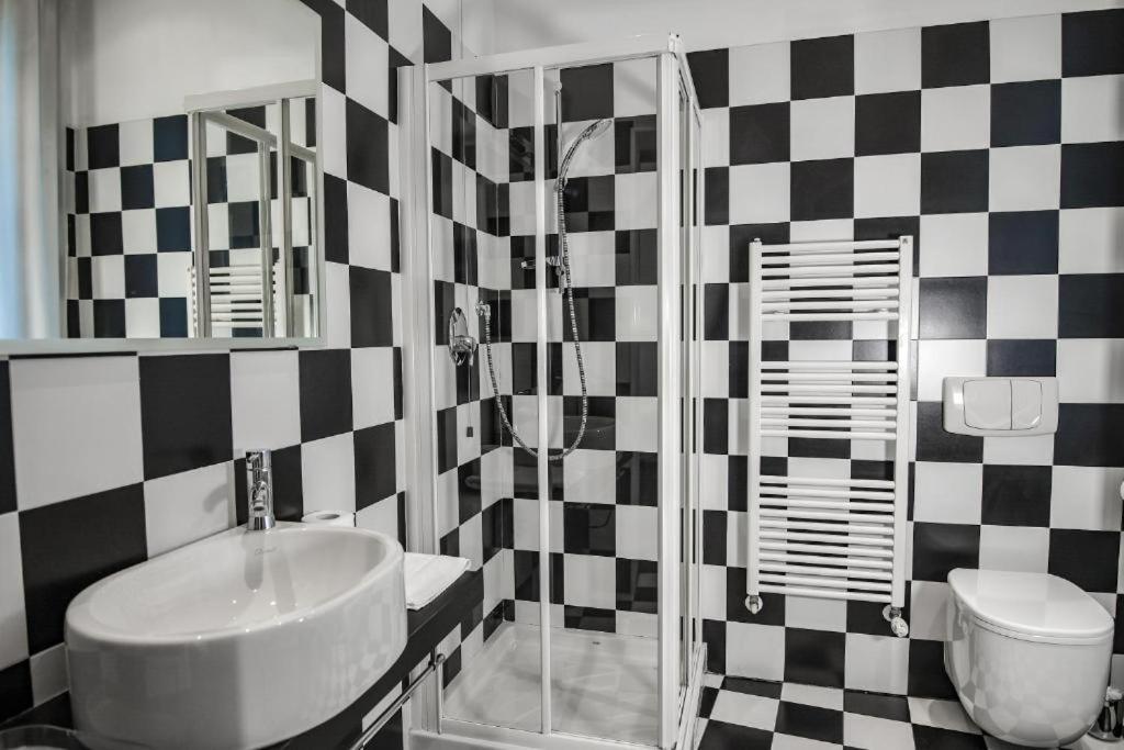 un bagno bianco e nero con lavandino e servizi igienici di Al Castello a Ferrara