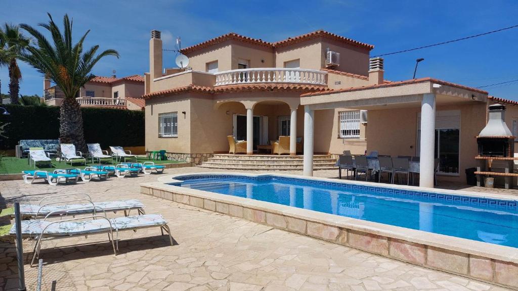 eine Villa mit einem Pool vor einem Haus in der Unterkunft Buena Vista in L'Ametlla de Mar