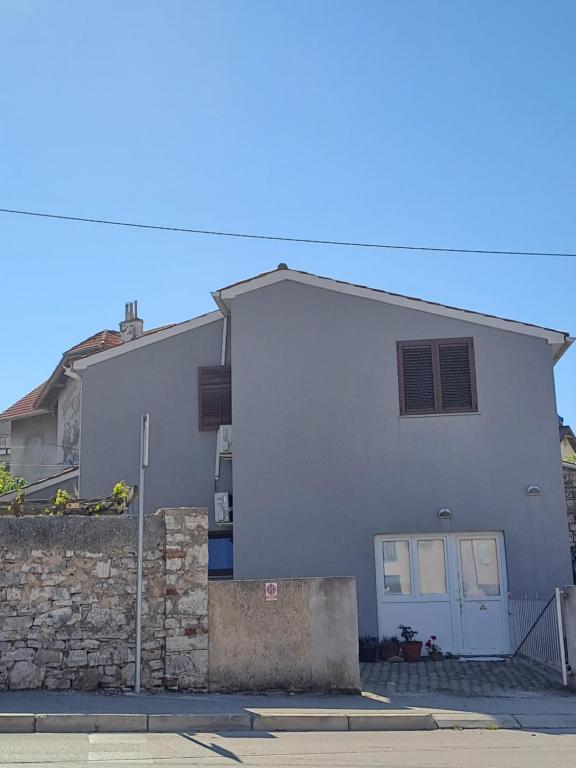una casa blanca con un muro de piedra en Budget Cozy, en Pula