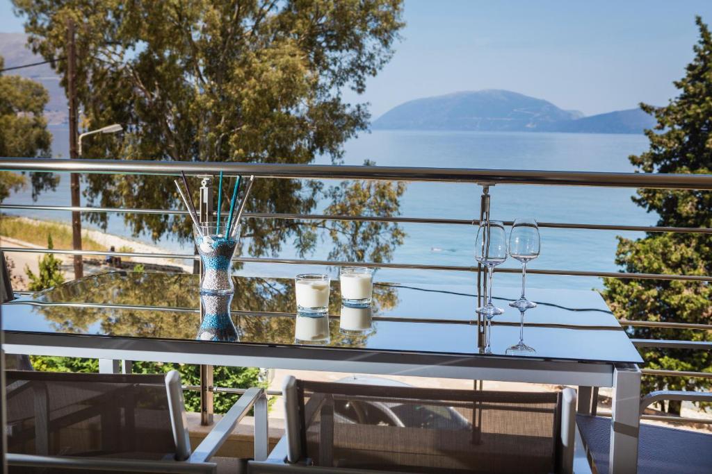 a table with wine glasses and a view of the water at Eucalyptus suite sea view in Karavomylos