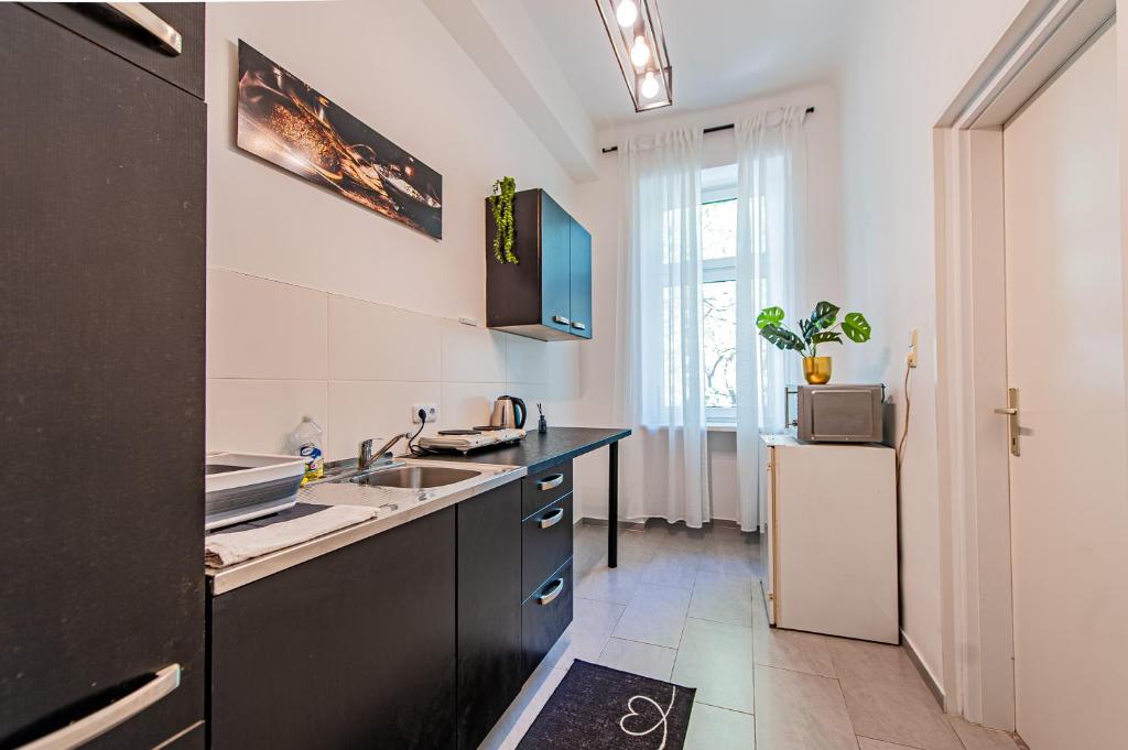a kitchen with a sink and a refrigerator at My city apartment- Vienna ArtRoom in Vienna