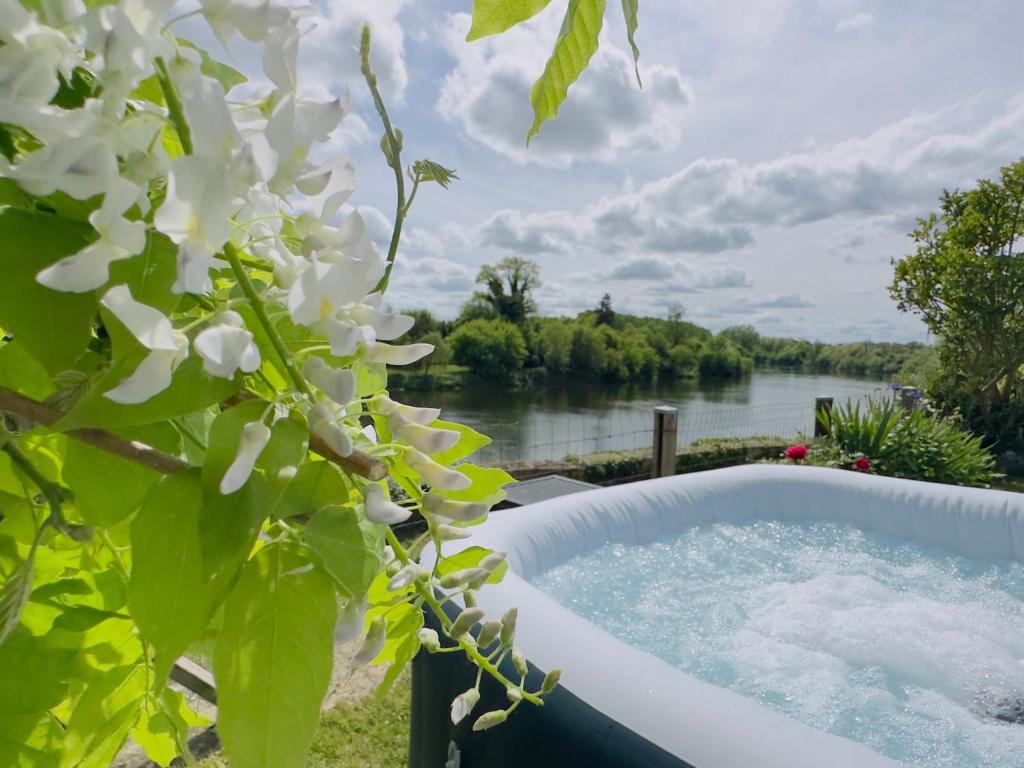 a bath tub with a view of a river at Gîte "Au Bord de l'Eau" in La Force