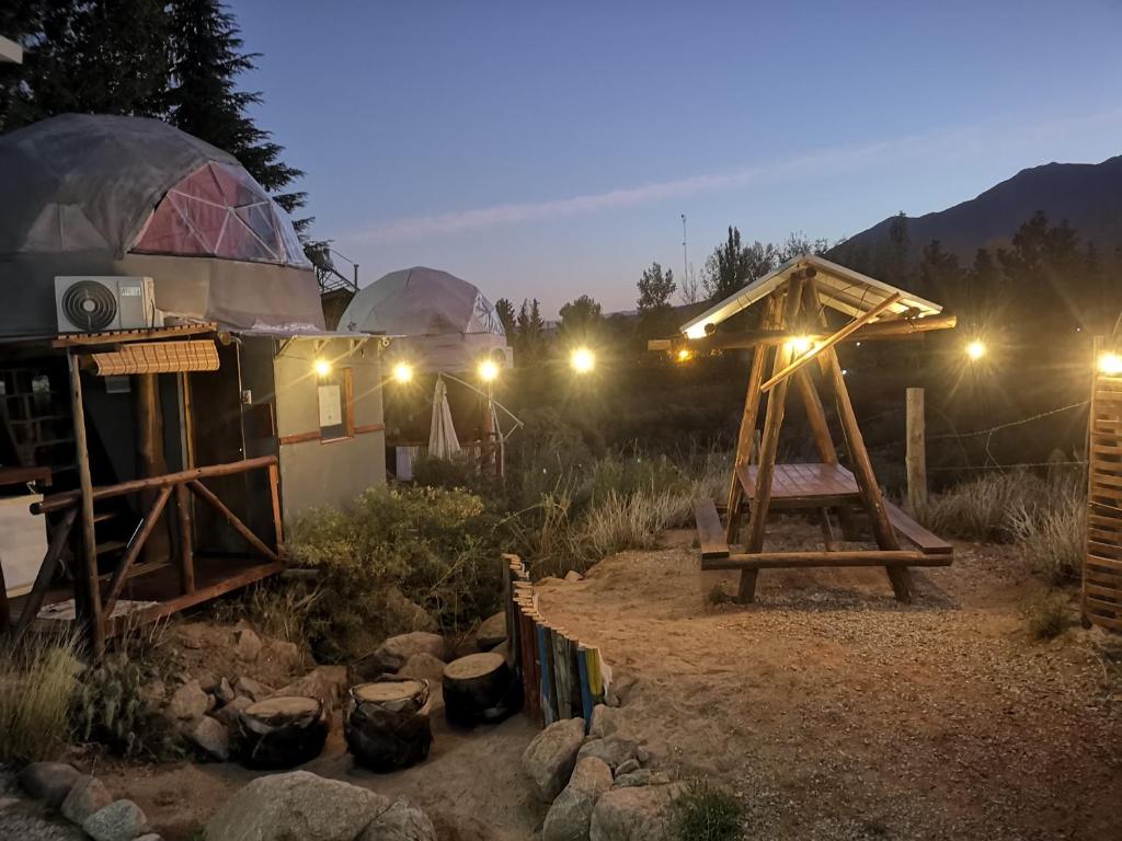 a yurt with a wooden table and a tent at Glamping Mendoza in Ciudad Lujan de Cuyo