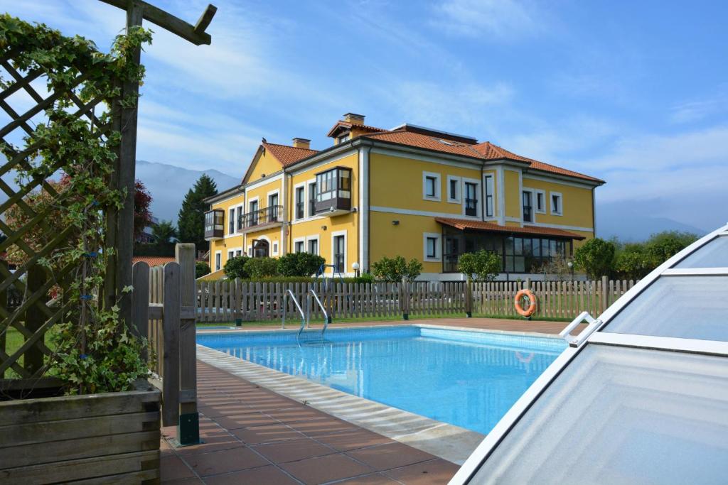 a villa with a swimming pool in front of a house at Hotel Finca La Mansión in Llanes