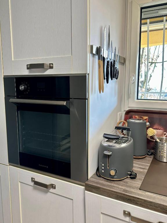 a kitchen with a stove and a toaster on a counter at Maison-Bonheur à 15 mn de Lyon in Beynost