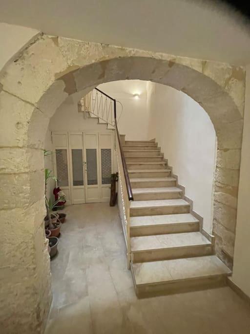 a staircase in a house with a stone archway at Sunset Ortigia-locazione turistica in Syracuse