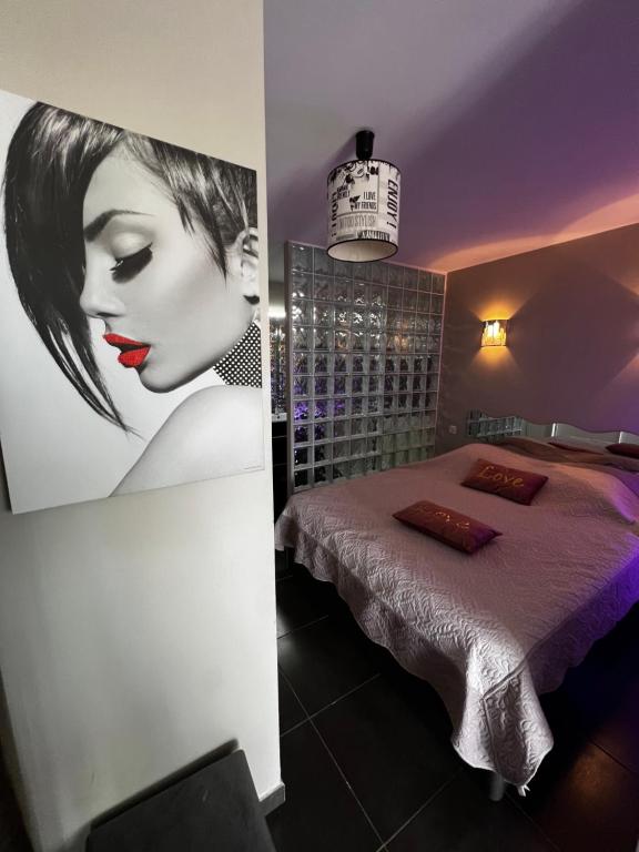 une chambre avec un lit et une photo d'une femme dans l'établissement Cap d’Agde, Village naturiste, port nature 5, coursive, au Cap d'Agde