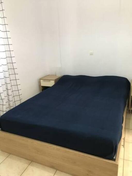 a bed in a room with a blue blanket on it at Marditsa's House by the sea in Serifos Chora