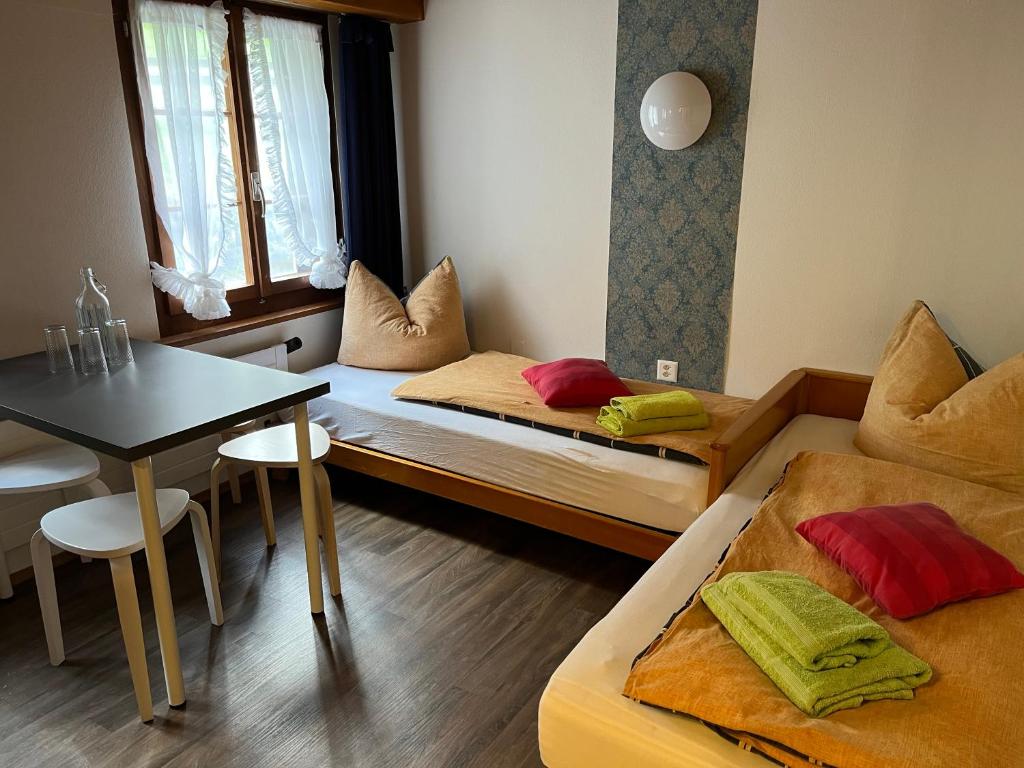 Kleines Zimmer mit 2 Betten und einem Tisch in der Unterkunft "Terrasse" Nessental in Gadmen