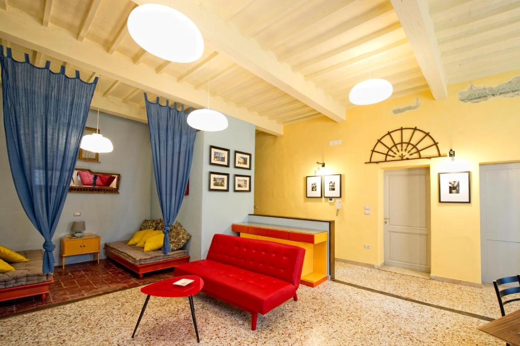 ein Wohnzimmer mit einem roten Sofa und einem Tisch in der Unterkunft Casa vacanze Fatucchi in Foiano della Chiana