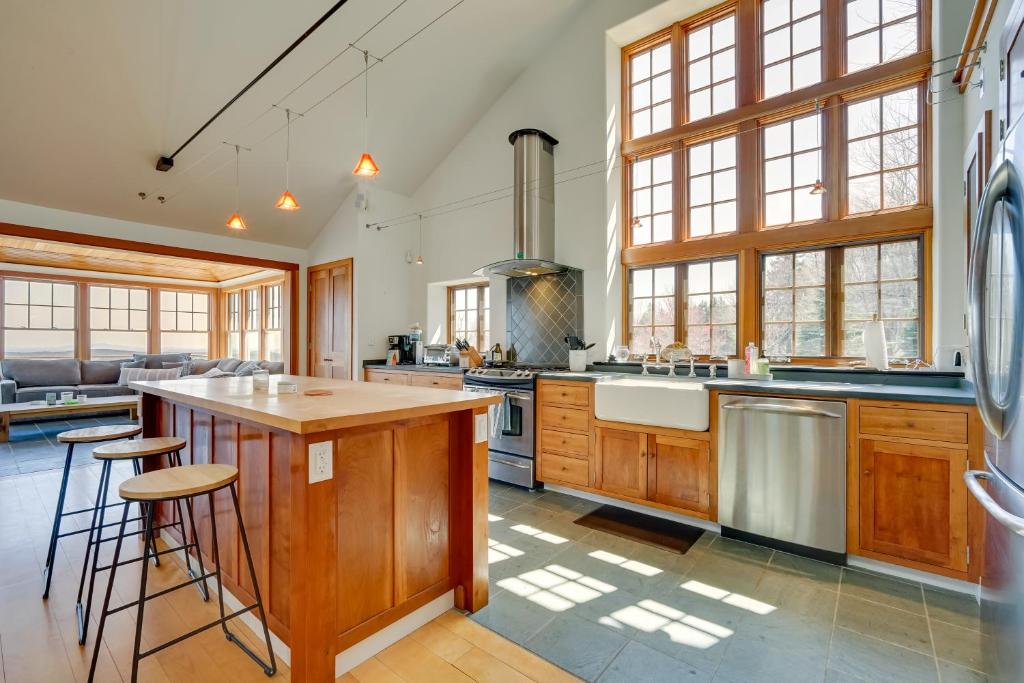a large kitchen with wooden cabinets and a large island at Peaceful Marlboro Vacation Rental with Sauna and Yard! in Marlboro
