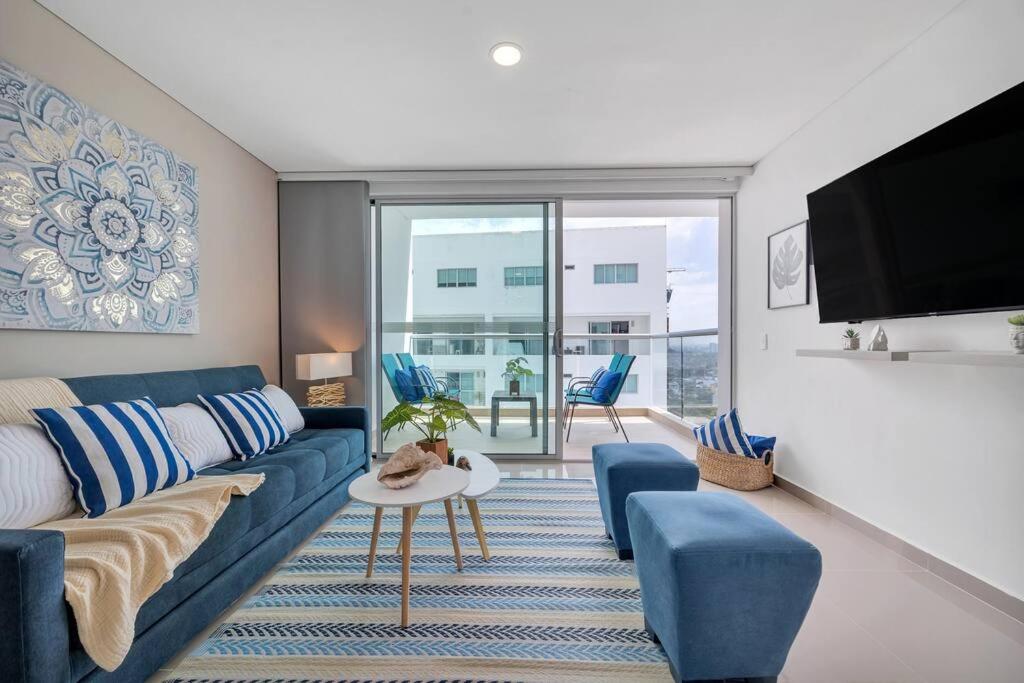 ein Wohnzimmer mit einem blauen Sofa und einem TV in der Unterkunft Montu 1404A Beautiful 2QueenBeds2bath w AC Near Beach in Cartagena de Indias