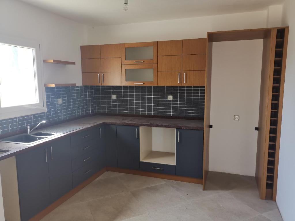 uma cozinha com armários azuis, um lavatório e uma janela em Iasos villa em Milas