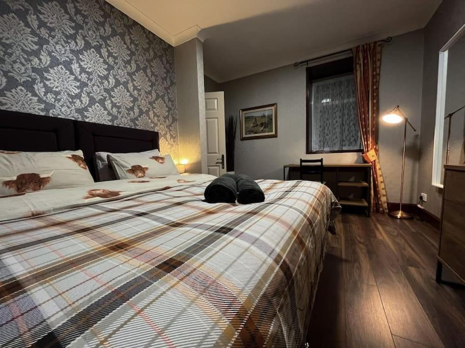 Un dormitorio con una cama con dos gatos. en The Nook Crieff - central 2-bed with garden :) en Crieff