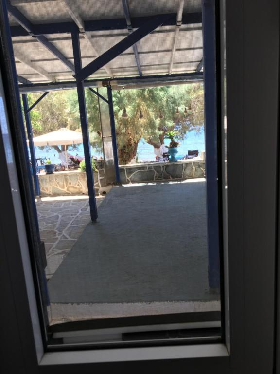 a view of a patio through a glass door at Marditsa's House by the sea in Serifos Chora