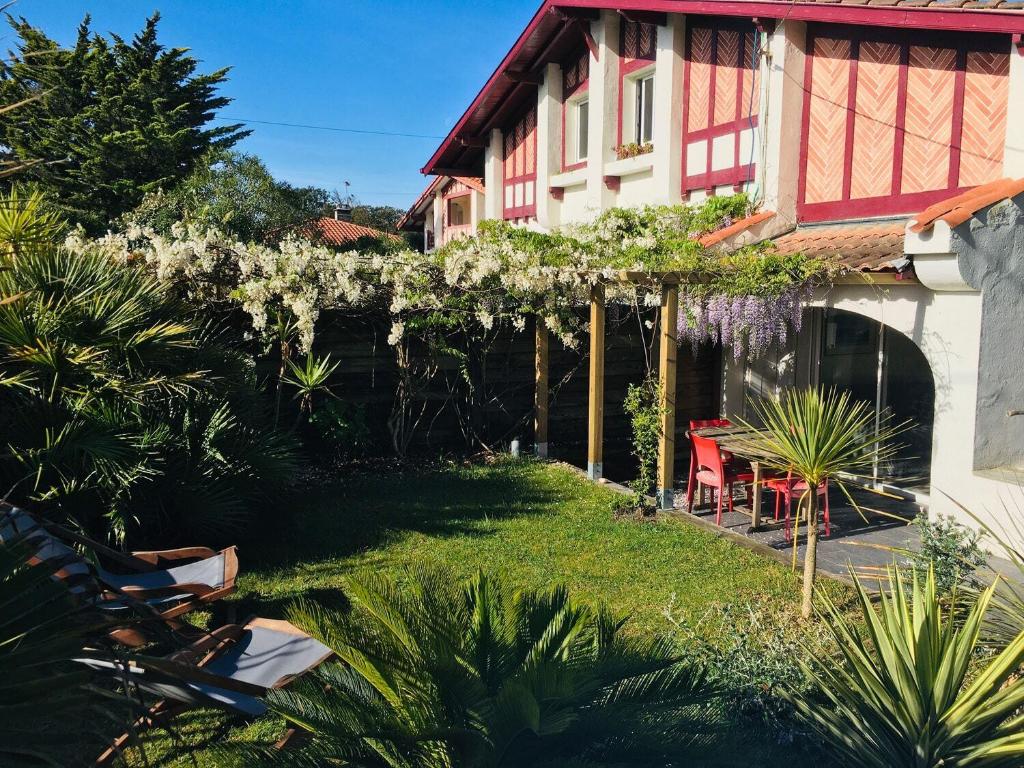 un jardin avec une maison fleurie dans l'établissement Appartement La Gravière, à Soorts-Hossegor