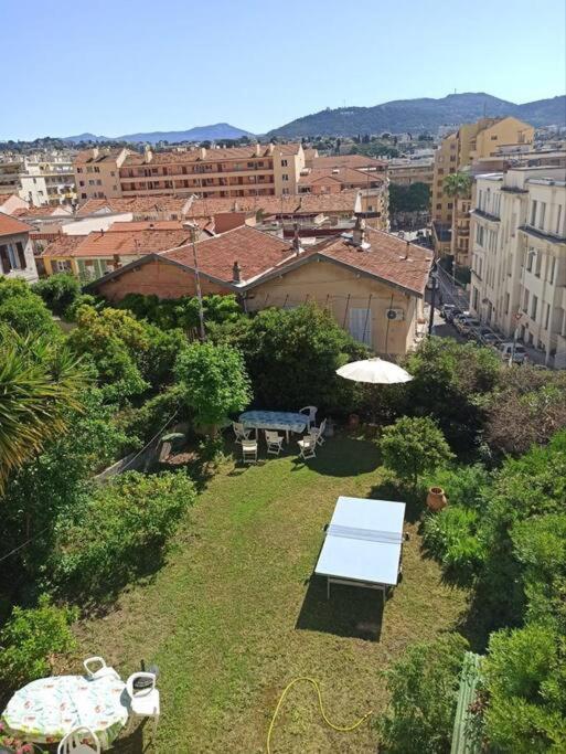 un parc avec un banc et un parasol dans une ville dans l'établissement Villa tres proche du centre ville, à Nice