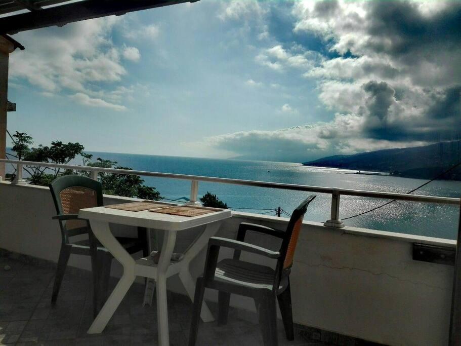 una mesa y sillas en un balcón con vistas al agua en Δίχωρο στούντιο στον κέντρο του Αρμενιστή, en Armenistis