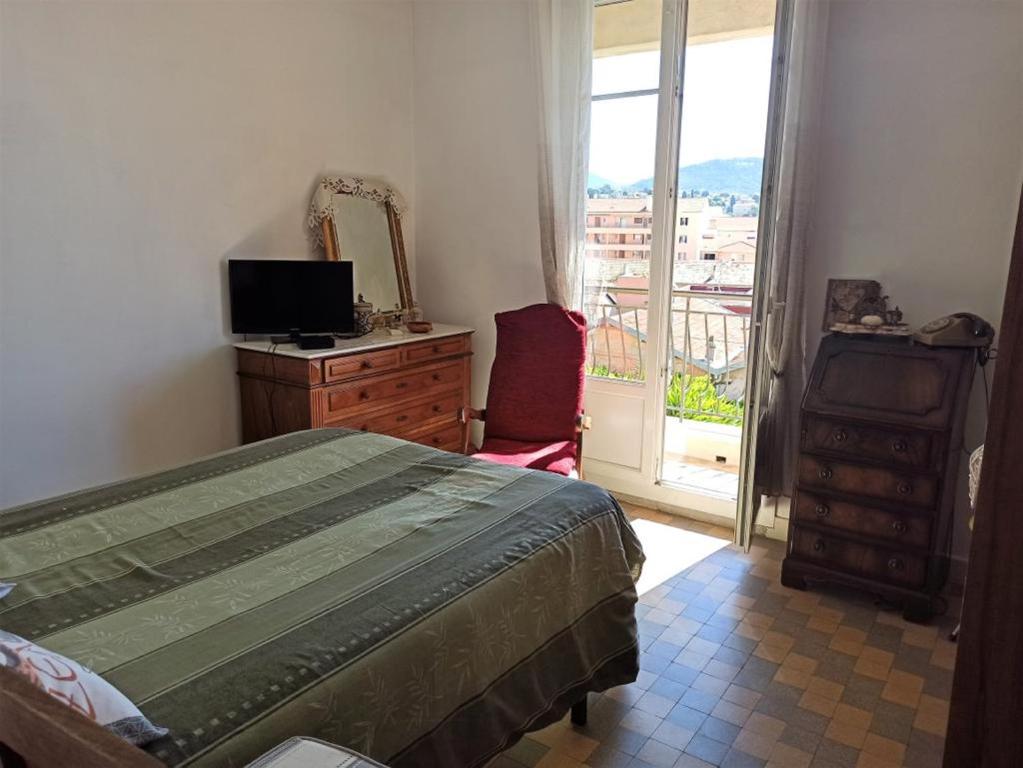 a bedroom with a bed and a dresser and a window at Villa tres proche du centre ville in Nice