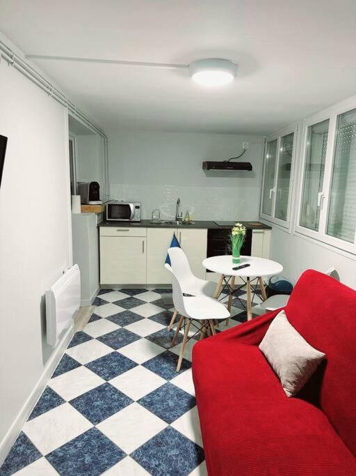 uma sala de estar com um sofá vermelho e uma mesa em Porte la chapelle appartement 4 personnes "Appart'5" em Pierrefitte-sur-Seine