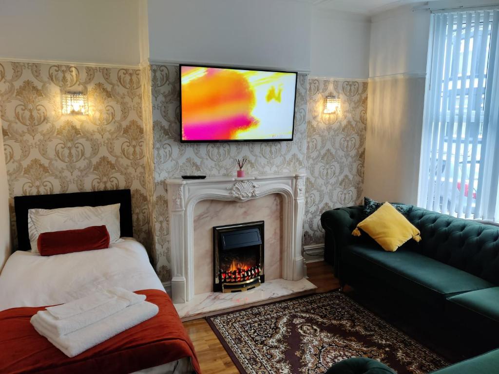 Liverpool Lux stay في ليفربول: غرفة معيشة مع موقد وتلفزيون على الحائط