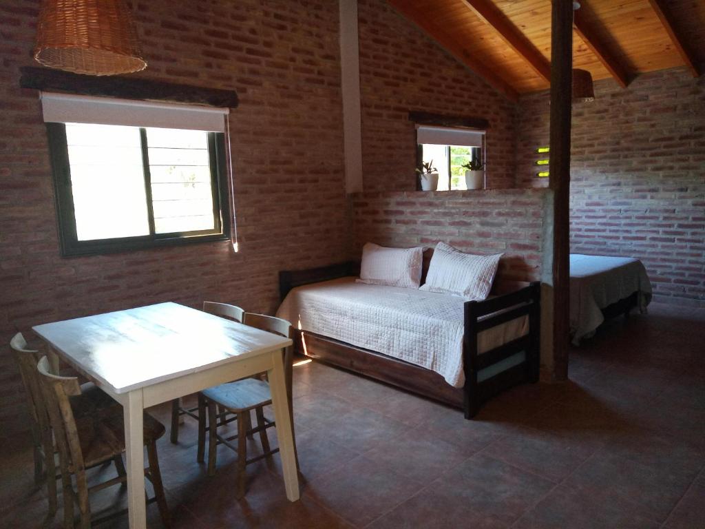Habitación con cama, mesa y ventana en La Quina., en Villa Rumipal