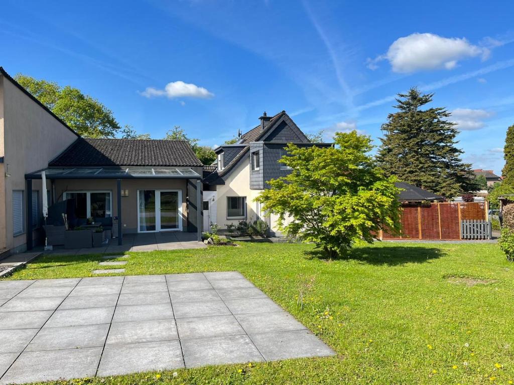 a house with a grass yard with a driveway at Xantener Ferienhaus Heeser Weg in Xanten