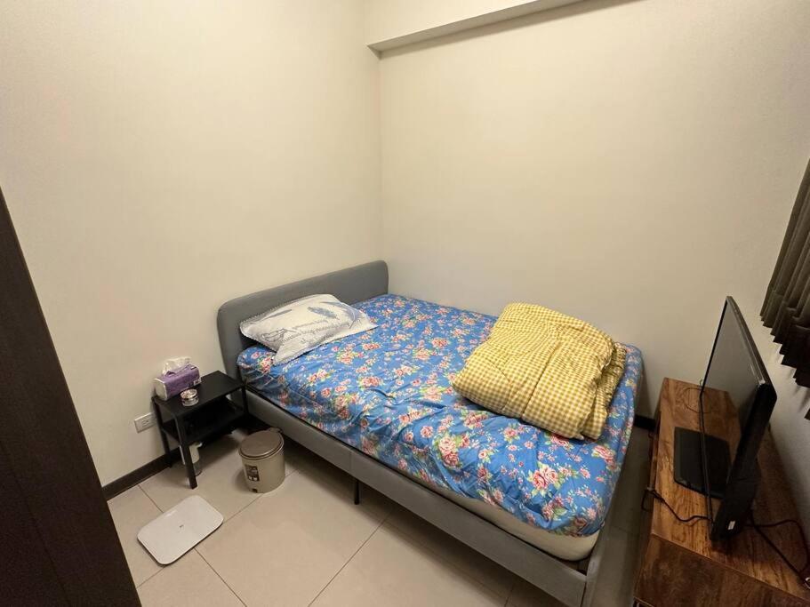 a small bedroom with a small bed with a blue blanket at MingHOW'S House 清水海線溫馨客房有雙人床位、電視、冷氣、獨立衣櫃 in Erh-t'ang-lang