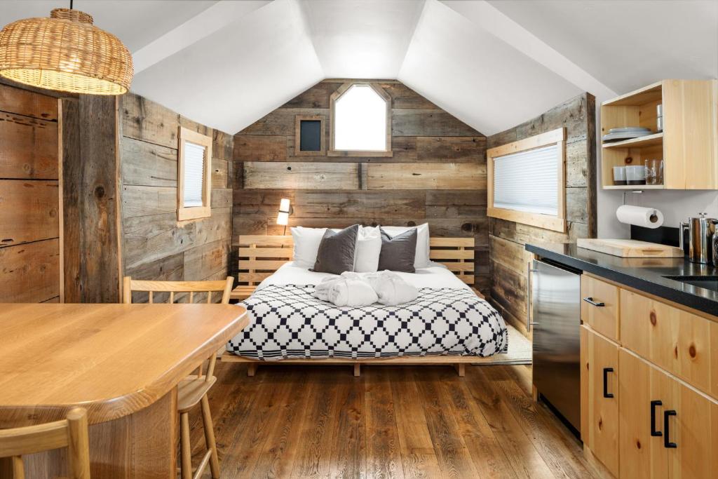 a bedroom with a bed in a room with wooden walls at Desolation Hotel Hope Valley in Markleeville