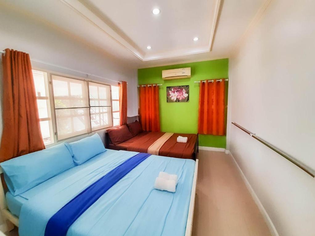 a bedroom with a blue bed and green walls at The Peak Pool villa, Huahin in Hua Hin