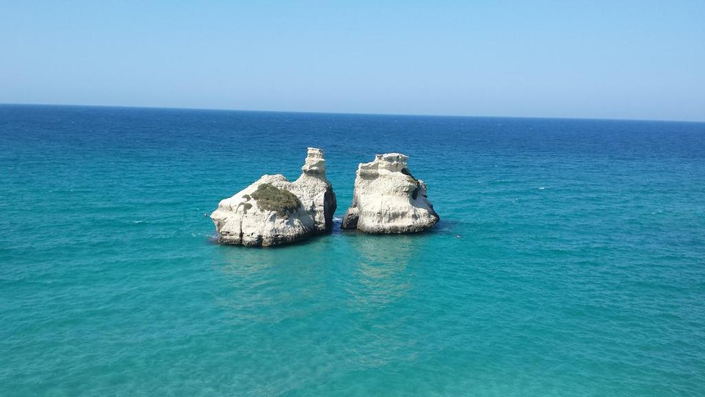 un grupo de rocas en medio del océano en Casa Soedo, en Torre dell'Orso