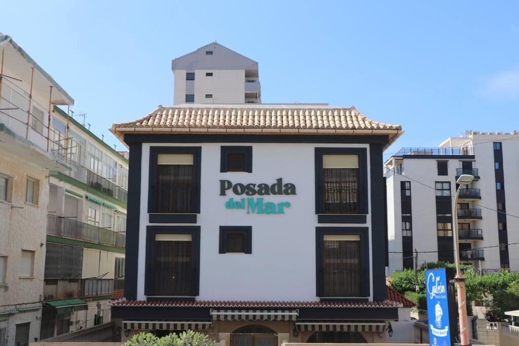 un edificio con un cartello sul lato di 104 I Posada del Mar I Encantador hostel en la playa de Gandia a Los Mártires