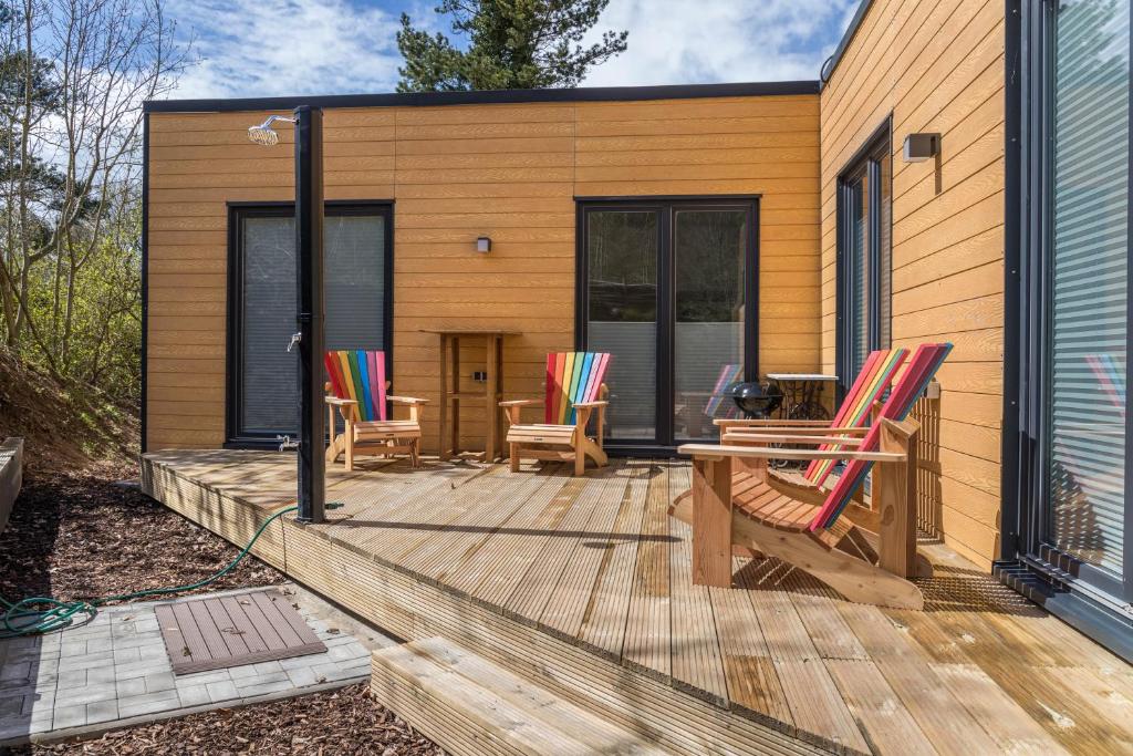 a house with a deck with chairs on it at Tinyhaus Brekendorf Kammberg in Brekendorf