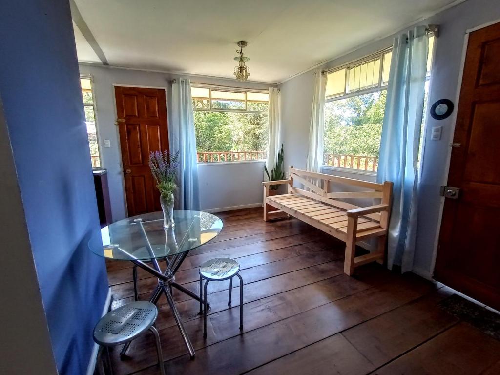 Zimmer mit einer Bank, einem Tisch und Fenstern in der Unterkunft Finca el Calar El mejor lugar para buscar la paz in Empalme