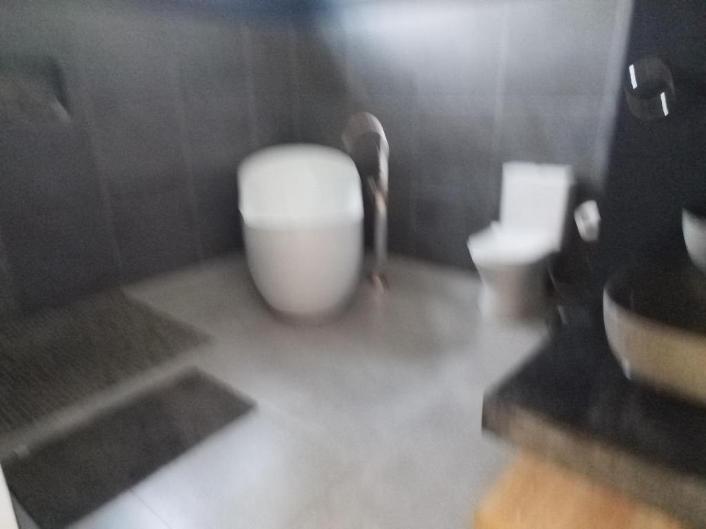 a bathroom with a white toilet and a sink at Le Reposier 