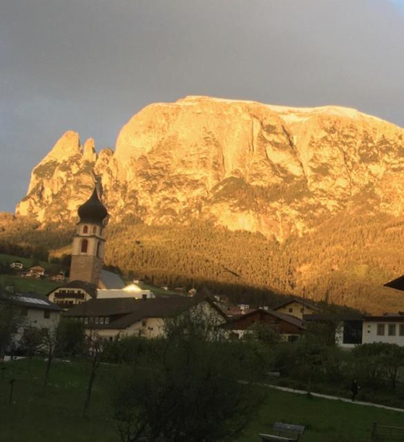a church in front of a large mountain at Apartment Maximilian in Völs am Schlern