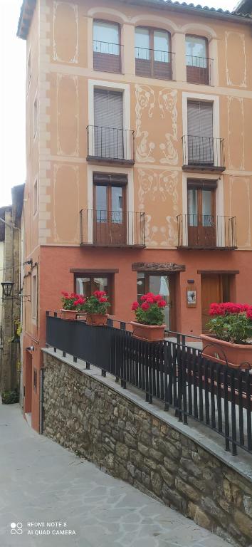 un bâtiment avec des boîtes de fleurs sur son côté dans l'établissement L'Urdet, à Sant Llorenc de Morunys