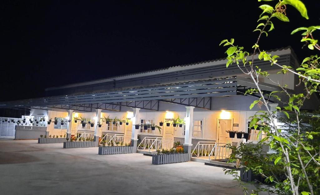 een verlicht gebouw met een rij zitplaatsen 's nachts bij Fancy Carp Resort Hua-Hin in Hua Hin