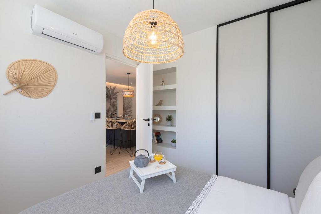 een slaapkamer met witte muren en een bed met een tafel bij KENYA parking gratuit in Annecy
