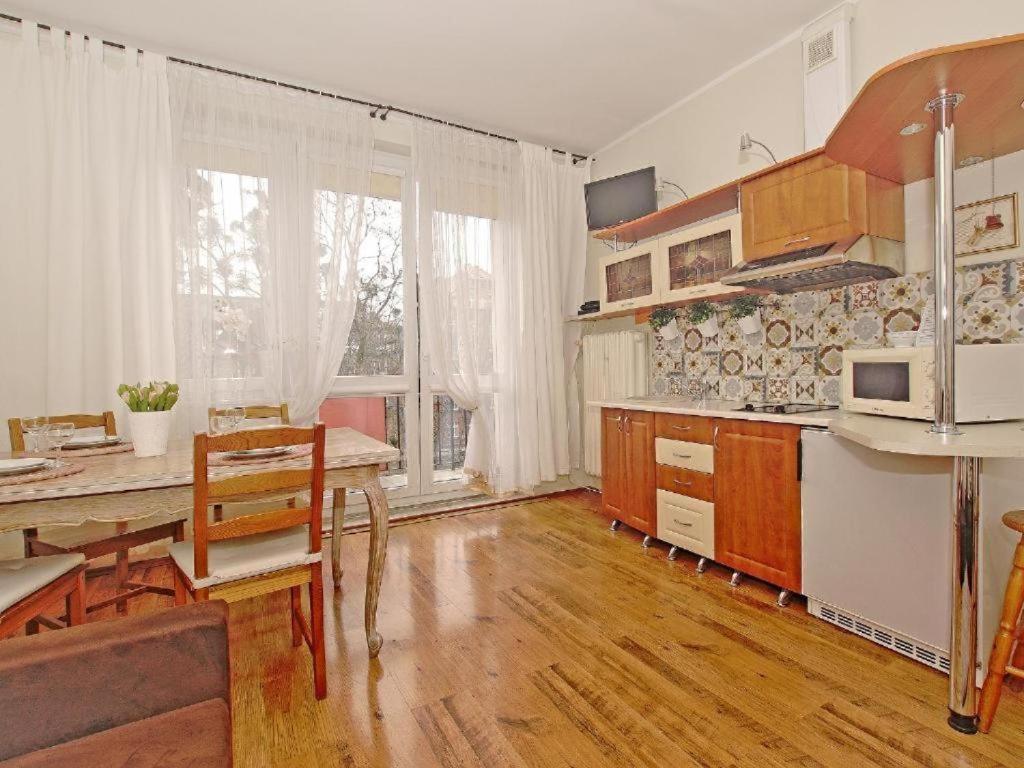 een keuken met een tafel en een eetkamer bij Apartament Kameralny 14 in Gdańsk