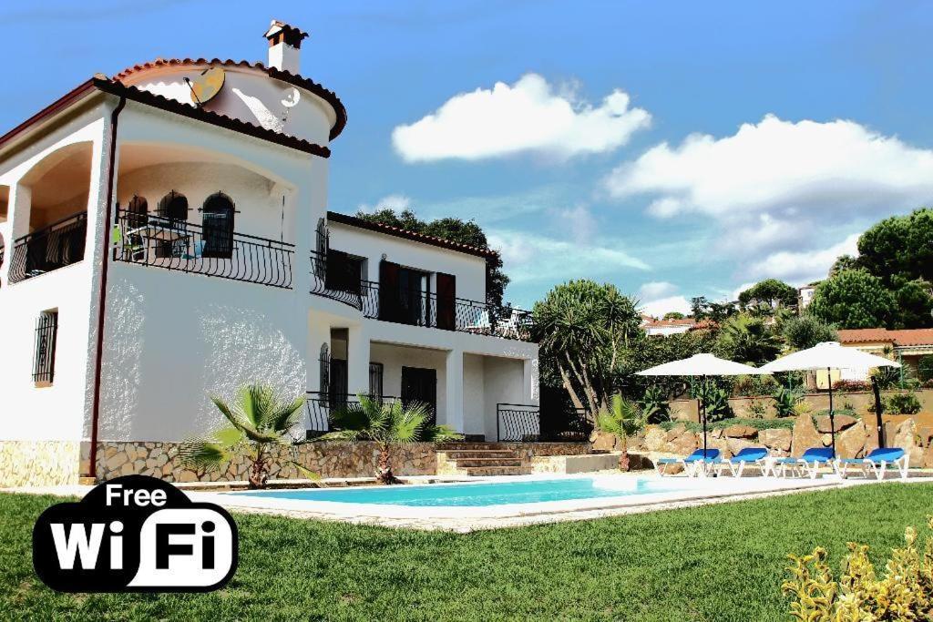 a villa with a swimming pool in front of a house at Villa Ensueño in Calonge