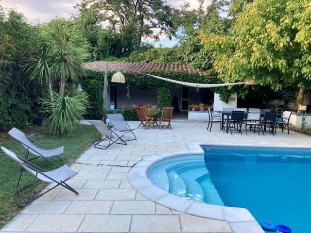 une piscine avec des chaises et une table ainsi qu'une terrasse dans l'établissement Studio indépendant terrasse piscine, à Avignon